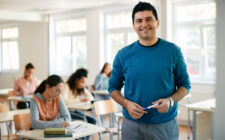 Retrato de professor feliz do ensino médio na sala de aula olhando para a câmera.