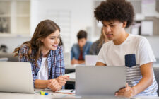 Estudantes do ensino médio na sala de aula estudando com seus notebooks.