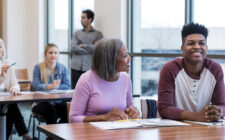 Pais e responsáveis com alunos durante reunião na escola.