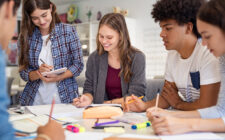 Grupo de alunos do ensino médio conversando sobre projetos.