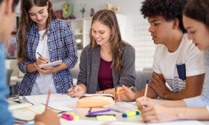 Grupo de alunos do ensino médio conversando sobre projetos.