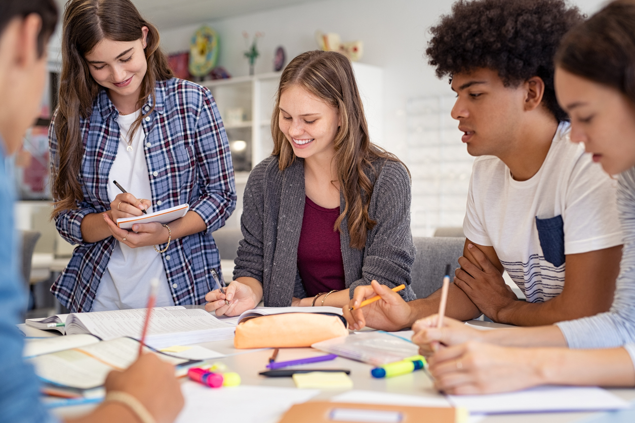 Grupo de alunos do ensino médio conversando sobre projetos.