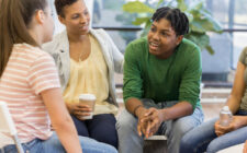 Alunos do ensino médio em roda de conversa com professora.