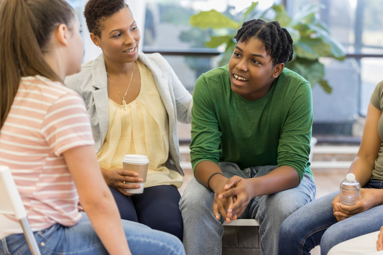 Alunos do ensino médio em roda de conversa com professora.